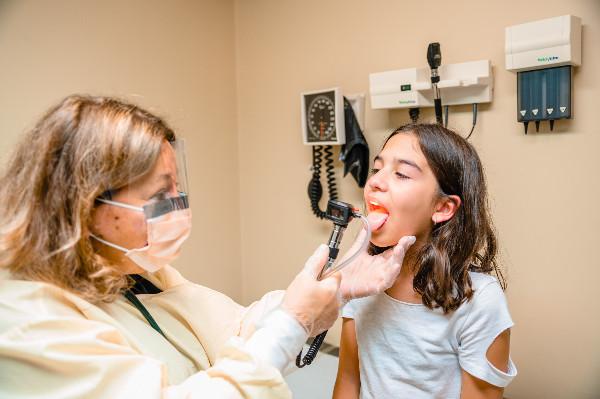 a girl getting her throat examined