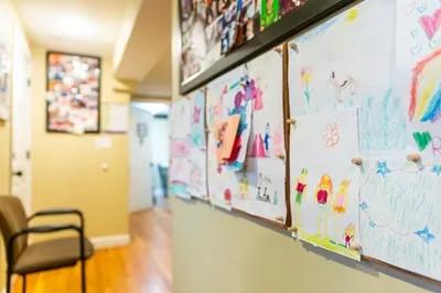 a wall of handdrawn pictures in a hallway